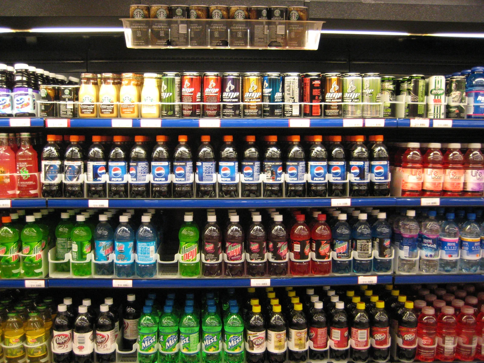 Canettes de sodas alignées, exemple typique de boisson ultra-transformée riche en additifs