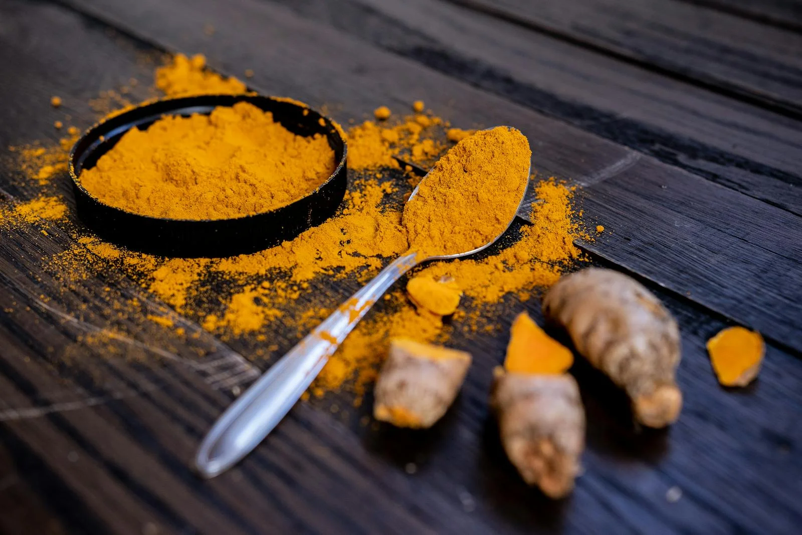 Rhizome frais de curcuma tenu à la main, illustrant la forme naturelle de cette plante médicinale