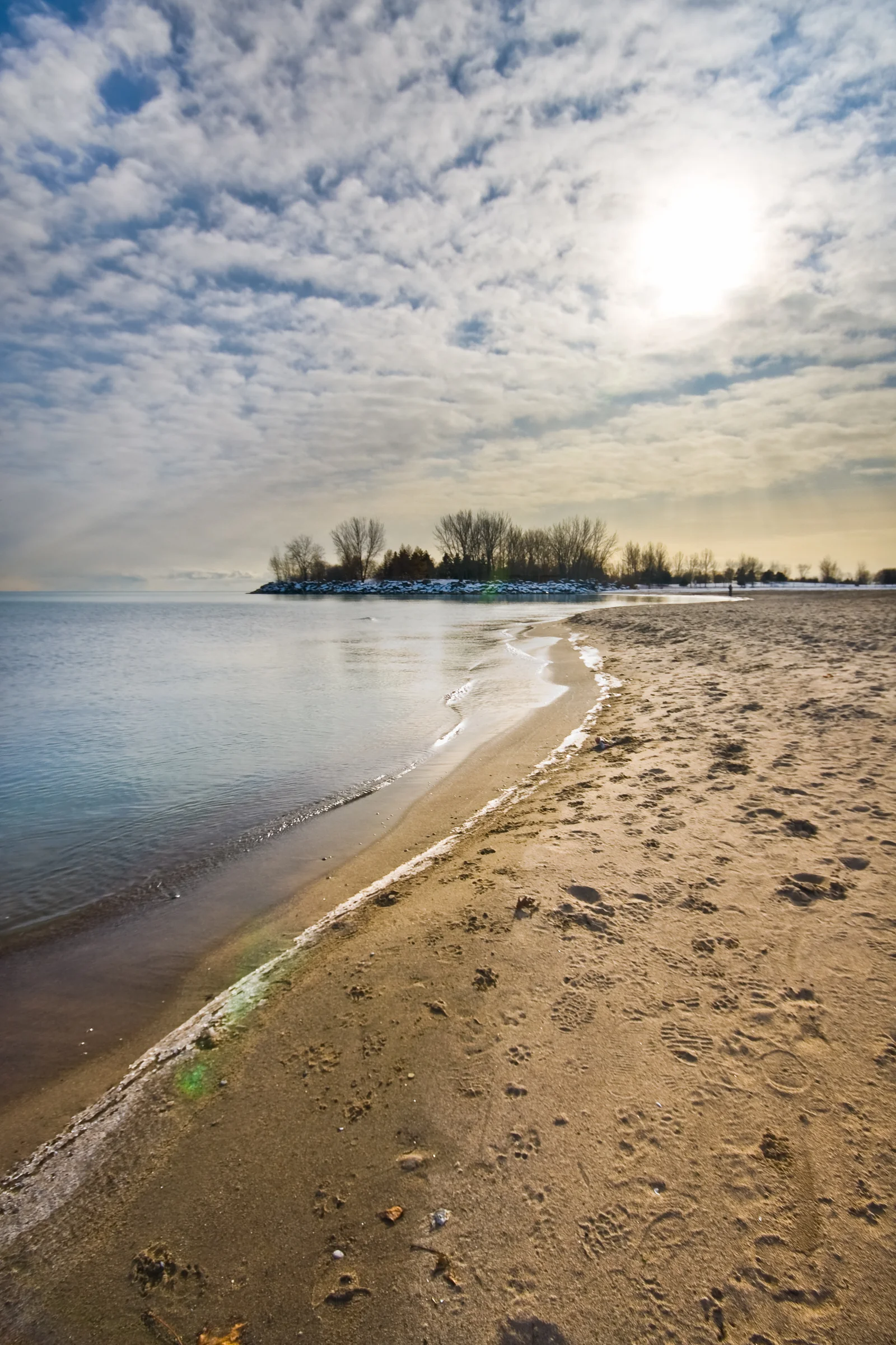 Empreintes de pas nus sur le sable d'une plage, illustrant la pratique du grounding