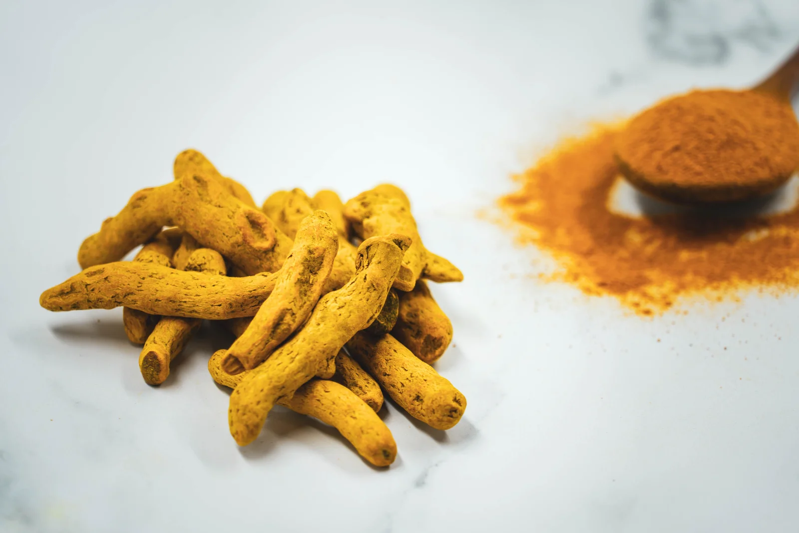 Racine et poudre de curcuma, aliment traditionnellement associé au soutien de l'organisme face à l'inflammation