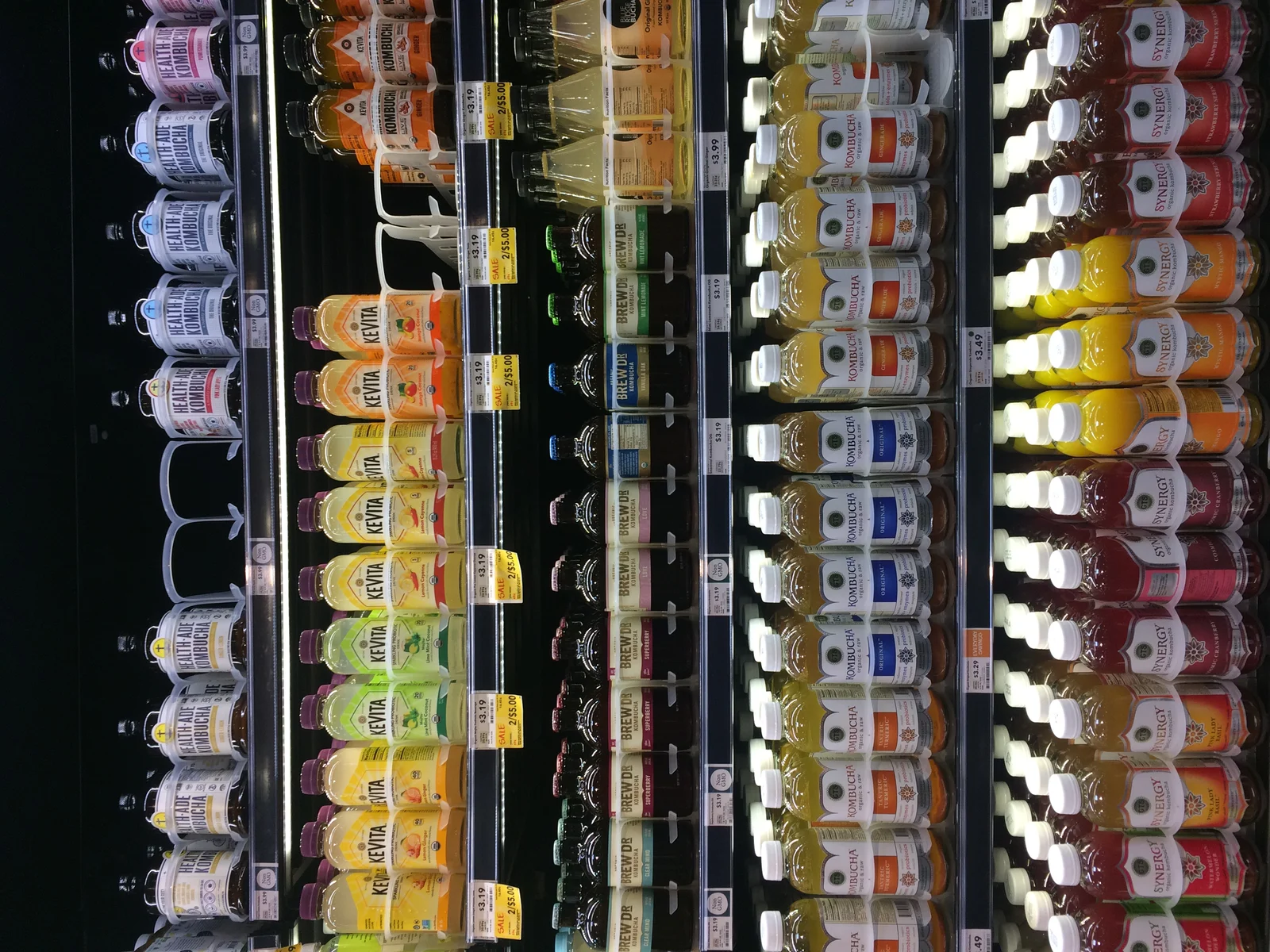 Rayon de bouteilles de kombucha en magasin bio, différentes marques et parfums