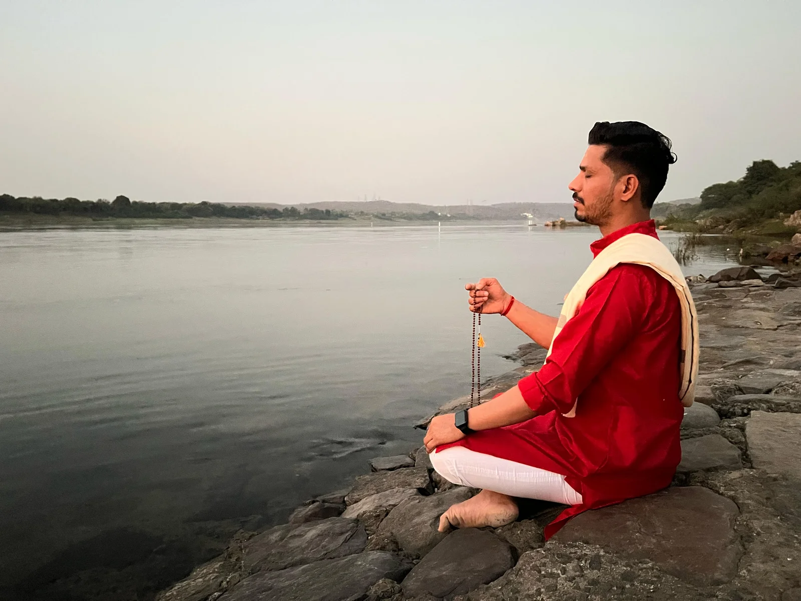 Personne pratiquant la méditation de pleine conscience en extérieur près d'une rivière