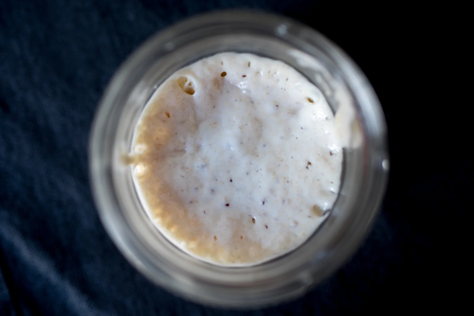 Levain naturel actif dans un bocal en verre, bulles de fermentation visibles