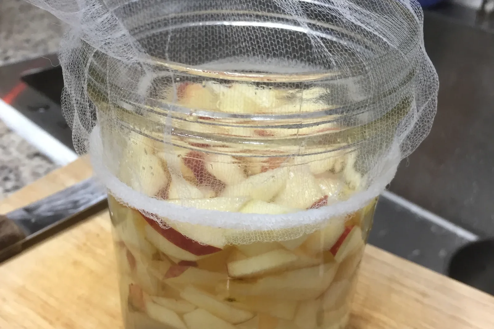 Fermentation maison du vinaigre de cidre dans un bocal en verre